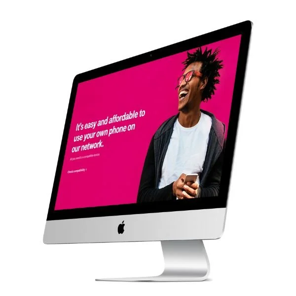 An Apple iMac computer with a bright pink screen showing a woman holding a phone and smiling, next to white text promoting network affordability.