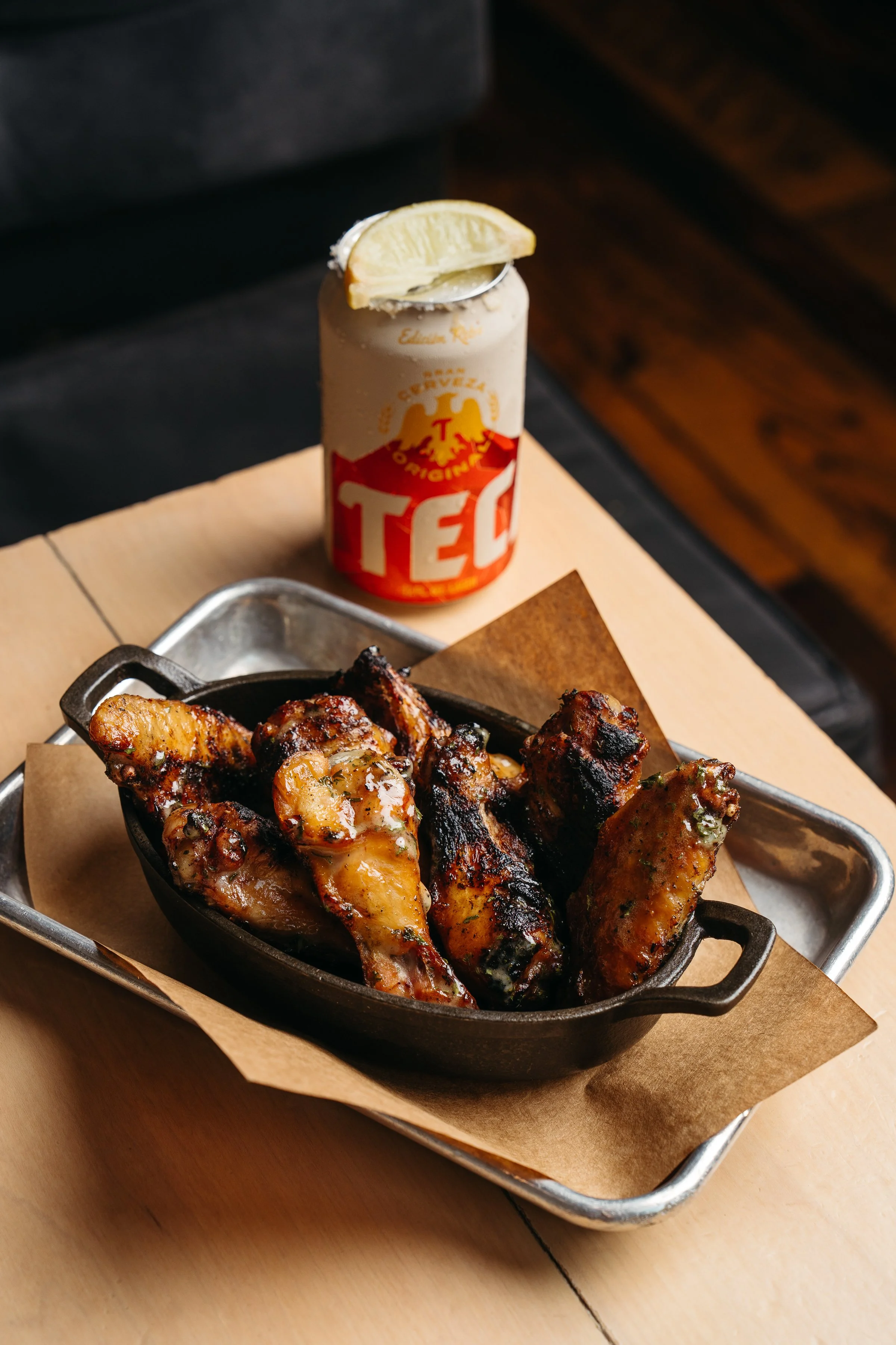 Slow-smoked chicken wings finished over live fire with house-made sauce at Butchertown Hall in Nashville