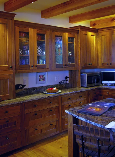 This cabinetry combines solid walnut insets and glass insets.
