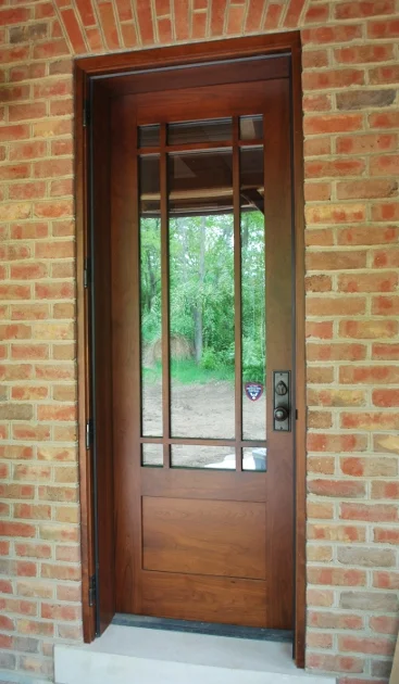 Custom walnut door allows access to the covered porch of a Kentucky timber frame home.