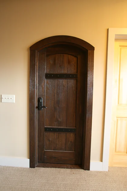 Custom stained oak with metal strapping makes a statment as the entry to the wine cellar in this upstate NY home.