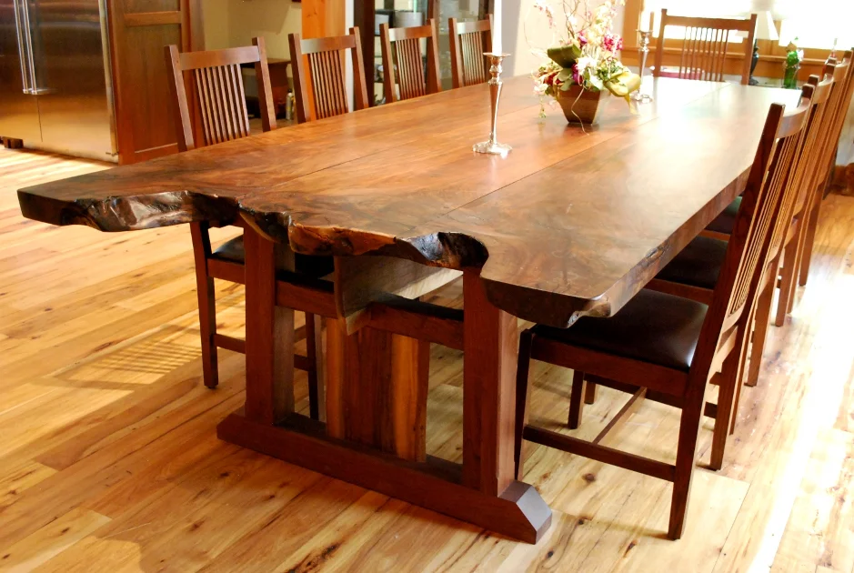 Slabs of claro walnut were crafted together maintaining live edges from the trunk and root area of the tree creating a very large family dining table.