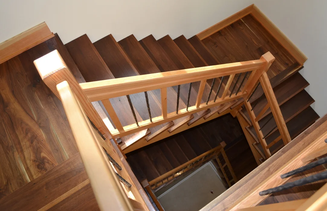 Walnut treads and landings join Douglas fir risers and railings to join two levels of a New York home.
