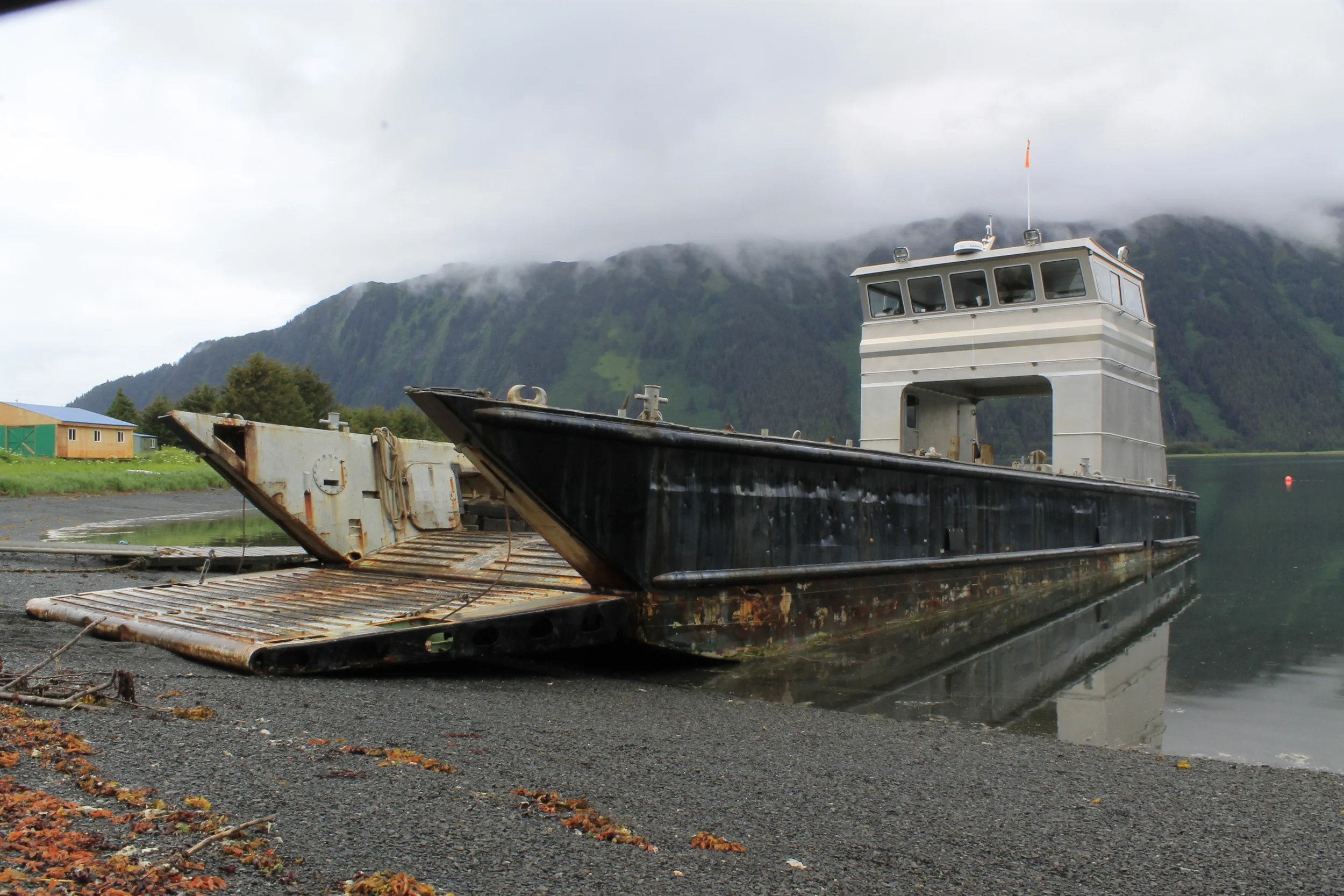 Shallow-draft landing craft M/V Oscar Mike offloading freight at a remote Alaskan shoreline