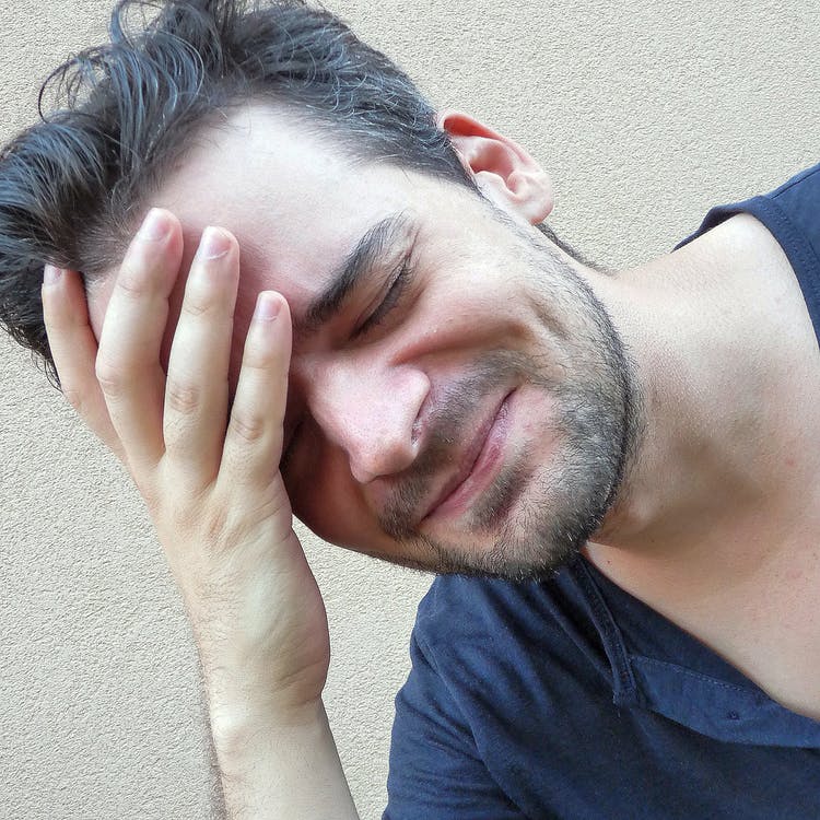 Man in pain with hand on forehead. Ultimate Health Personal Training Los Angeles/Hollywood