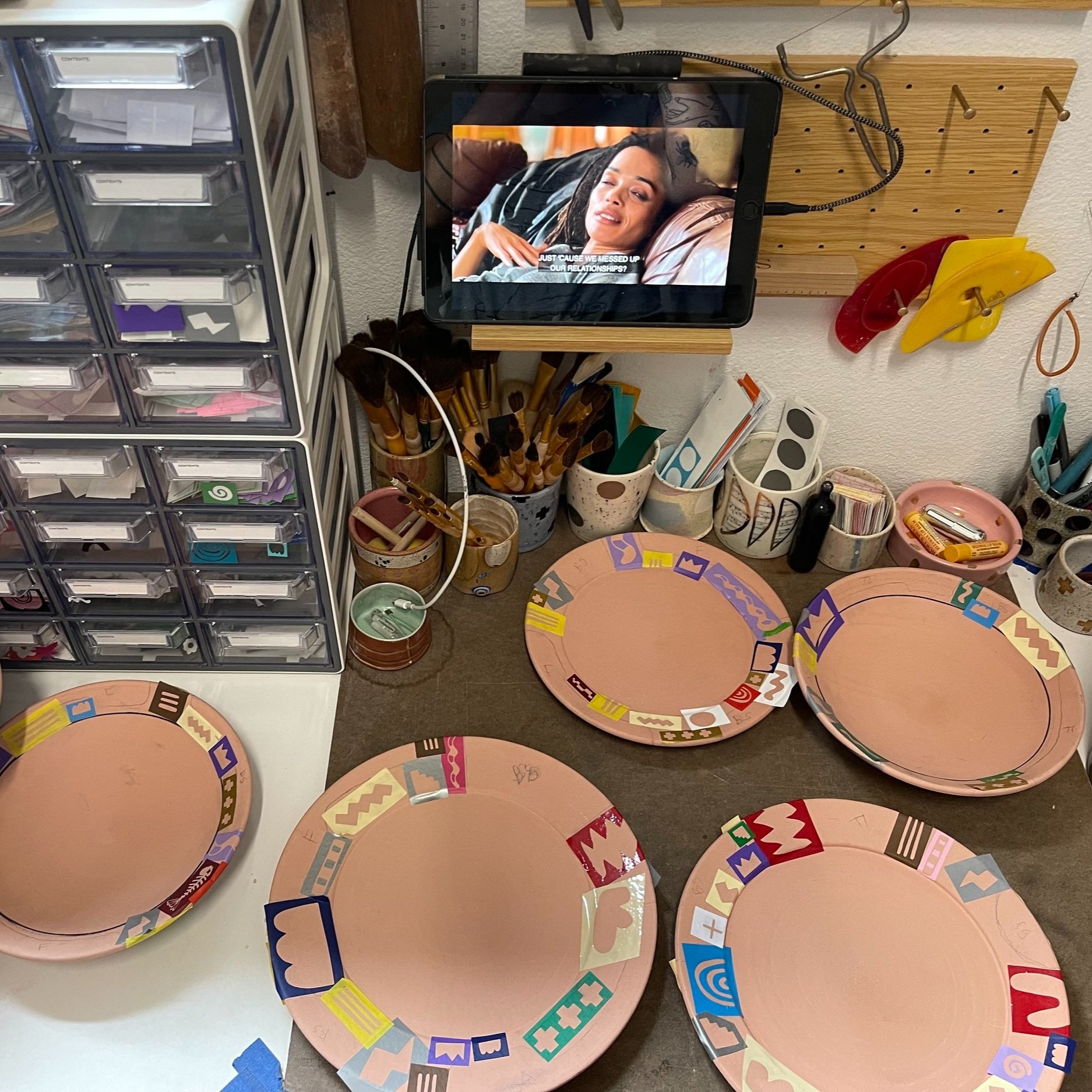  To the left: Organizational drawers for allllll of my stencils for glazing/decorating.  On the wall: Peg board for all of my most used clay tools  On my working table: also use my seconds pots as a way to organize brushes and tools/materials.     iP