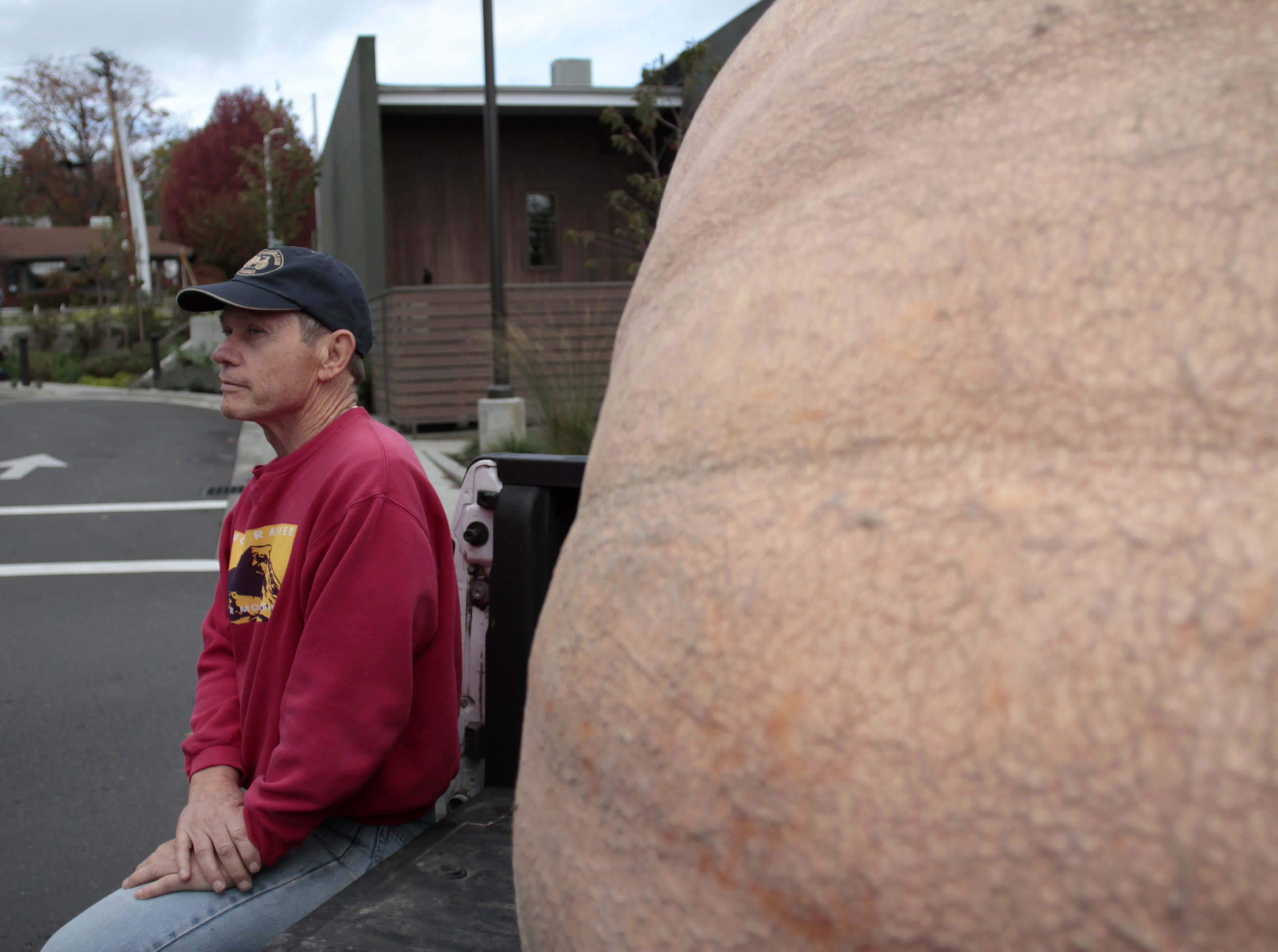  Joel Holland, a Puyallup-based farmer specializing in giant pumpkins, sits with his latest gigantic gourd (all 1,030 pounds of it),&nbsp;before delivering it to the Johansson Clark Real Estate office for their annual Halloween display.&nbsp; 