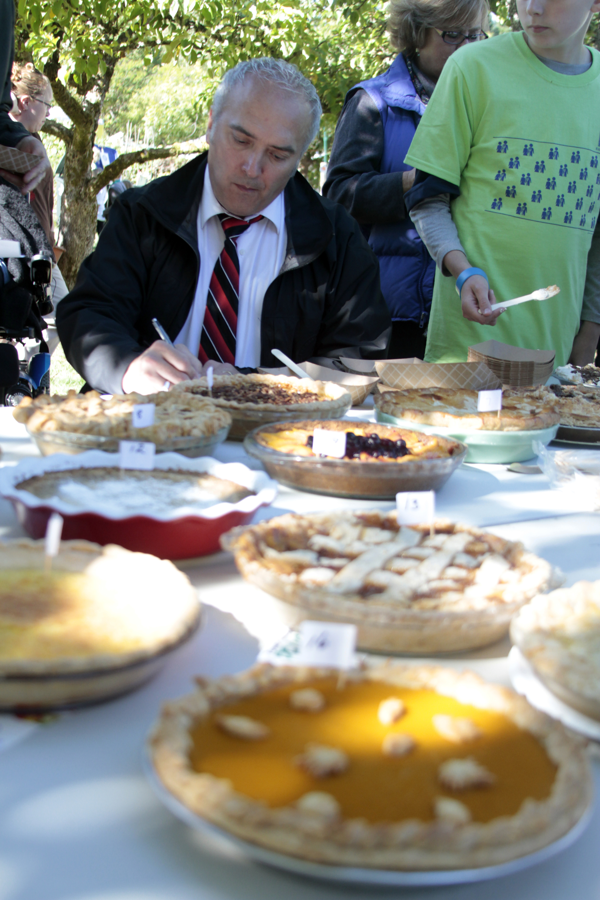  Bainbridge Island Police Chief Matthew Hamner uses his sleuthing skills, and carefully considers the evidence, to determine the best pie as one of several judges of the annual Harvest Fair contest.&nbsp; 