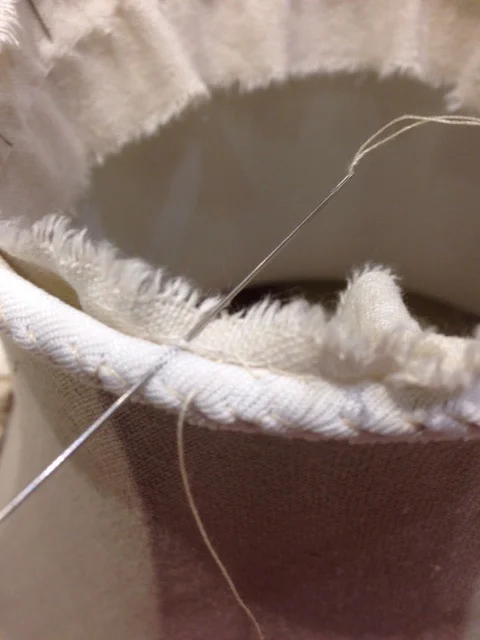 Hand stitching the trimming to the top. 