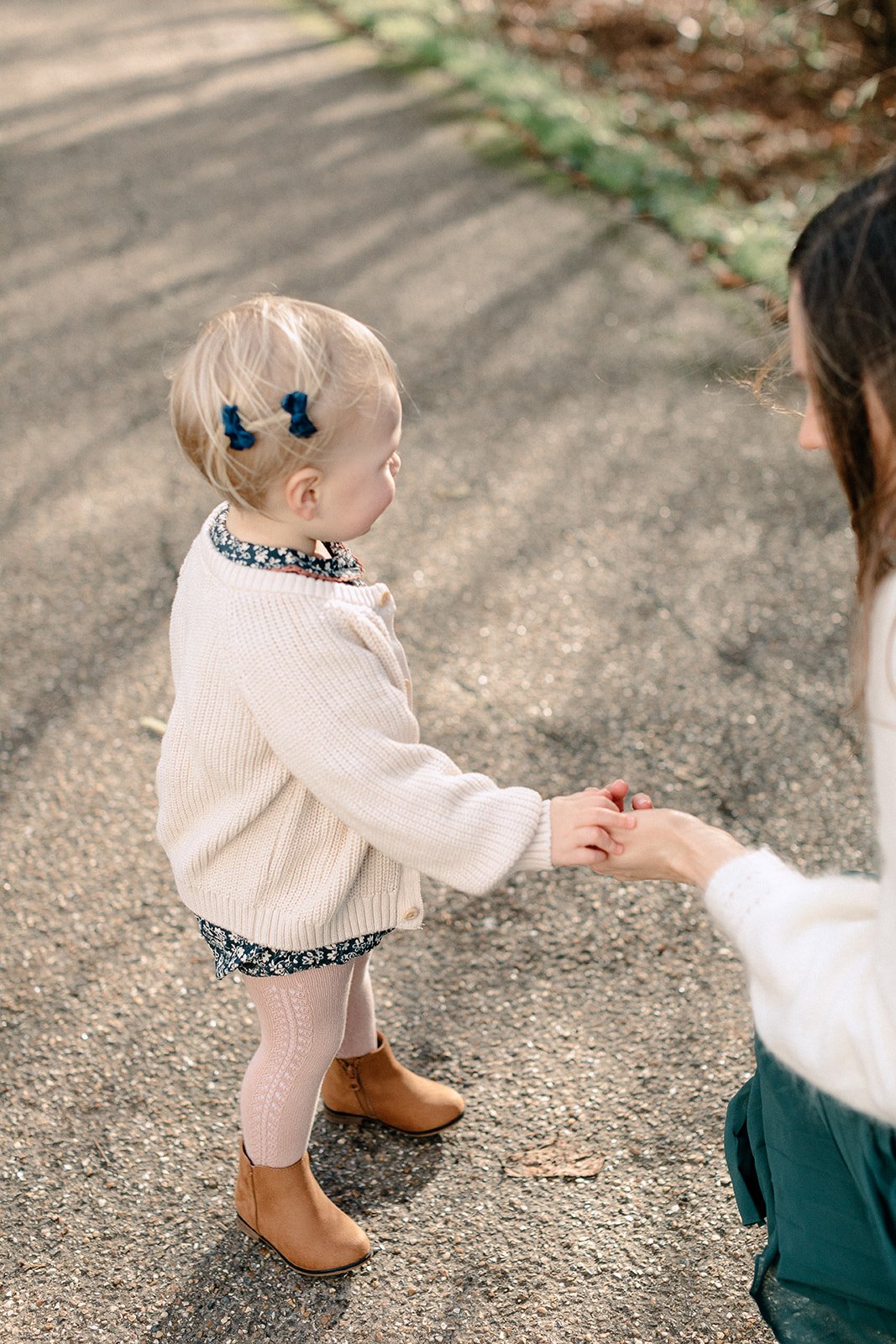  toddler holding mother’s hand at family photoshoot in Pembroke Lodge, Richmond Park 