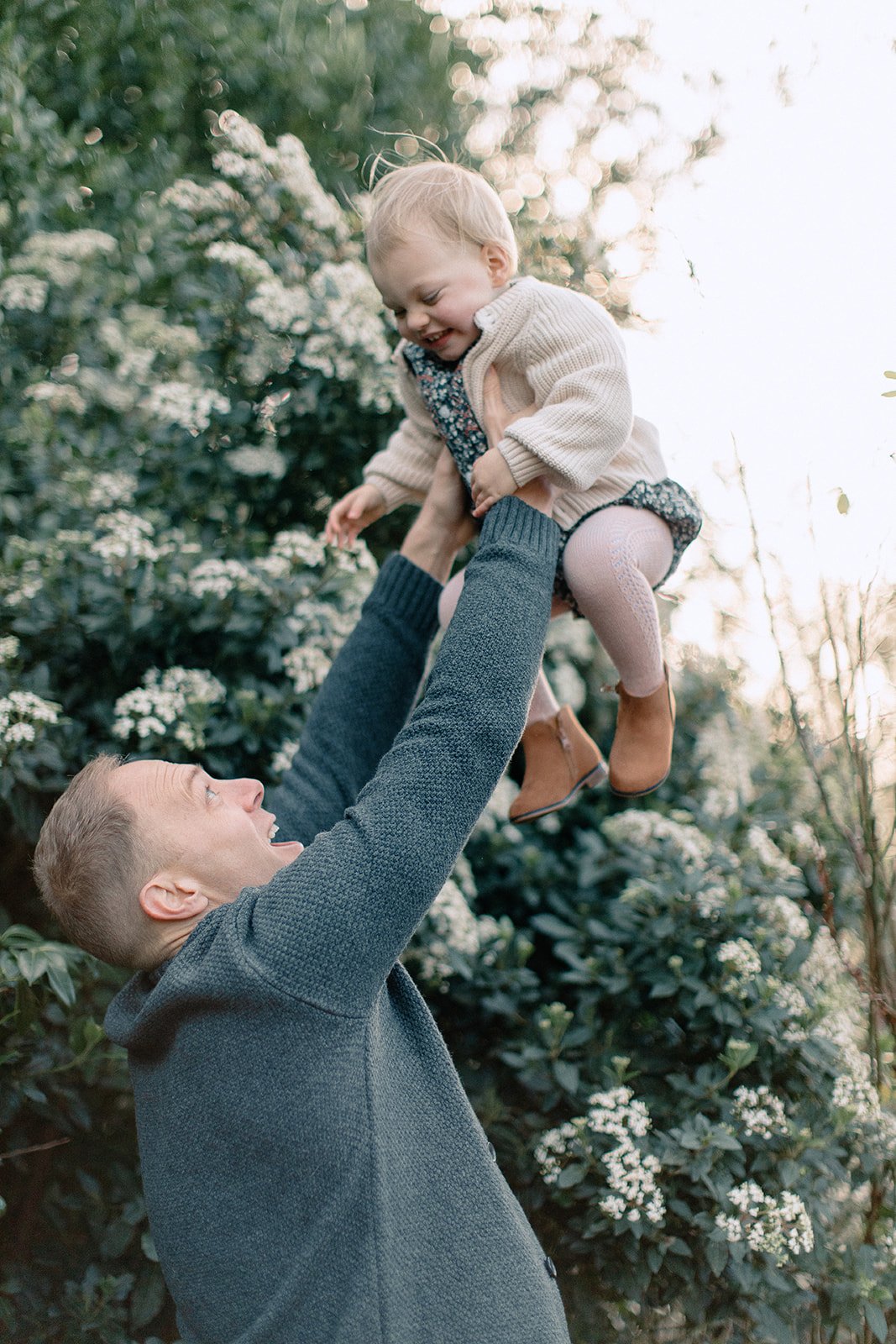  Family photography of father holding daughter in the air in richmond park London 