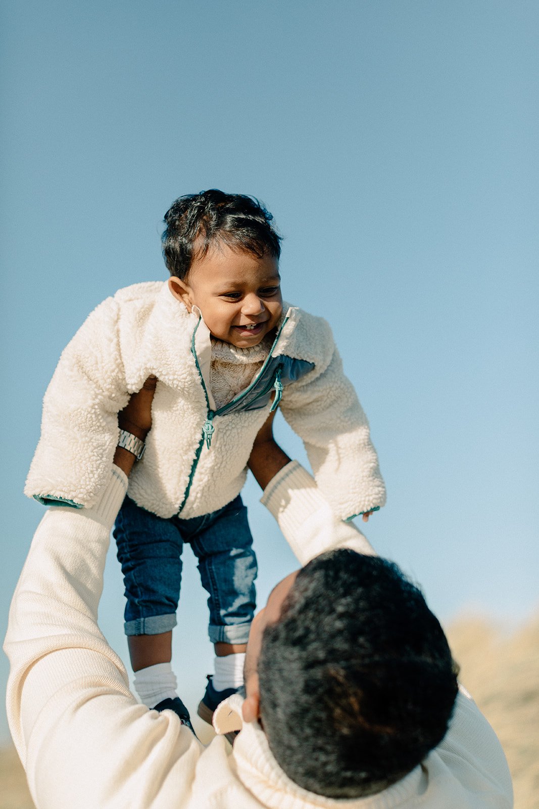  family photoshoot dad holding toddler in air at Camber Sands, Rye 