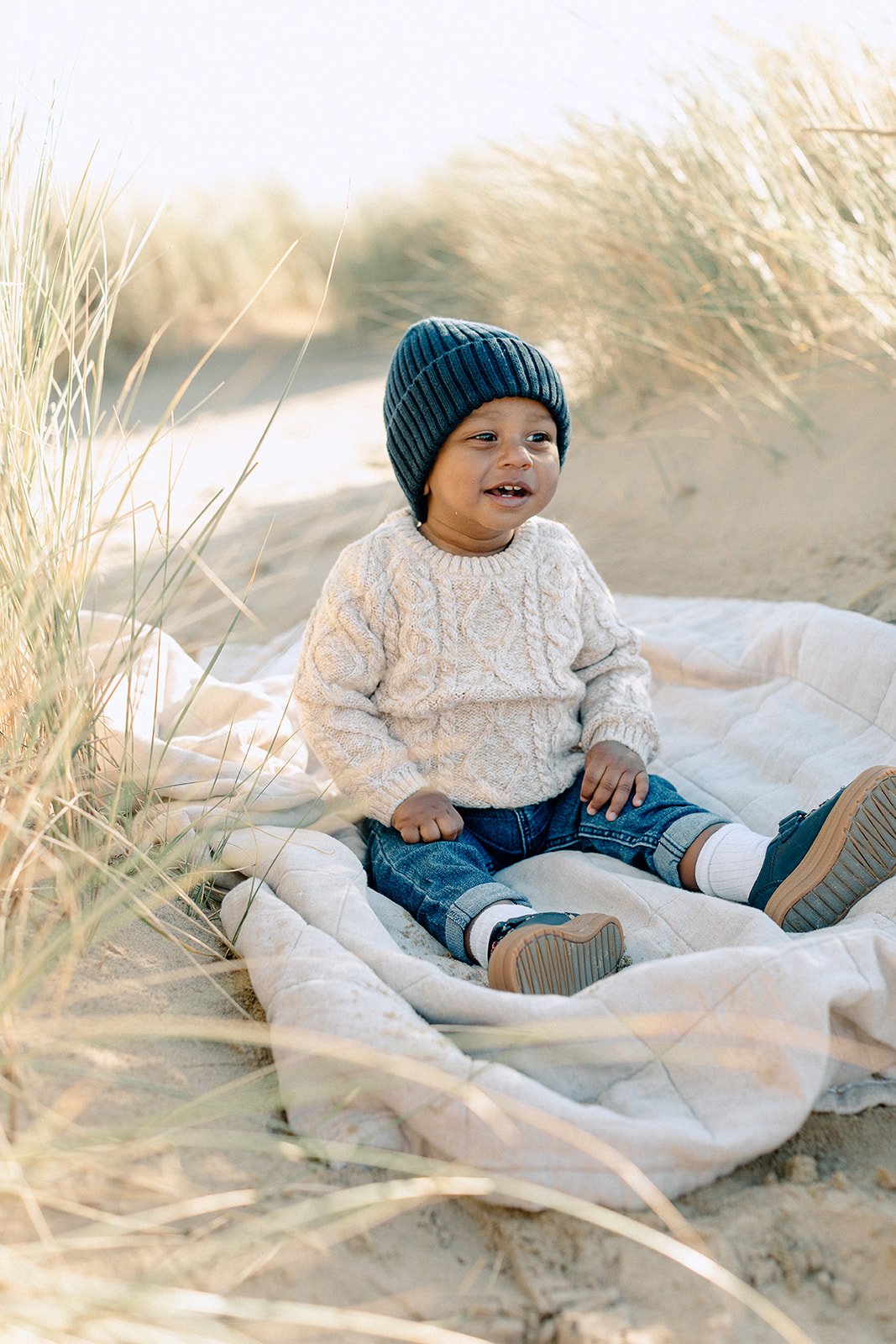  family photography of toddler sitting on sand dunes at Camber Sands, Rye 