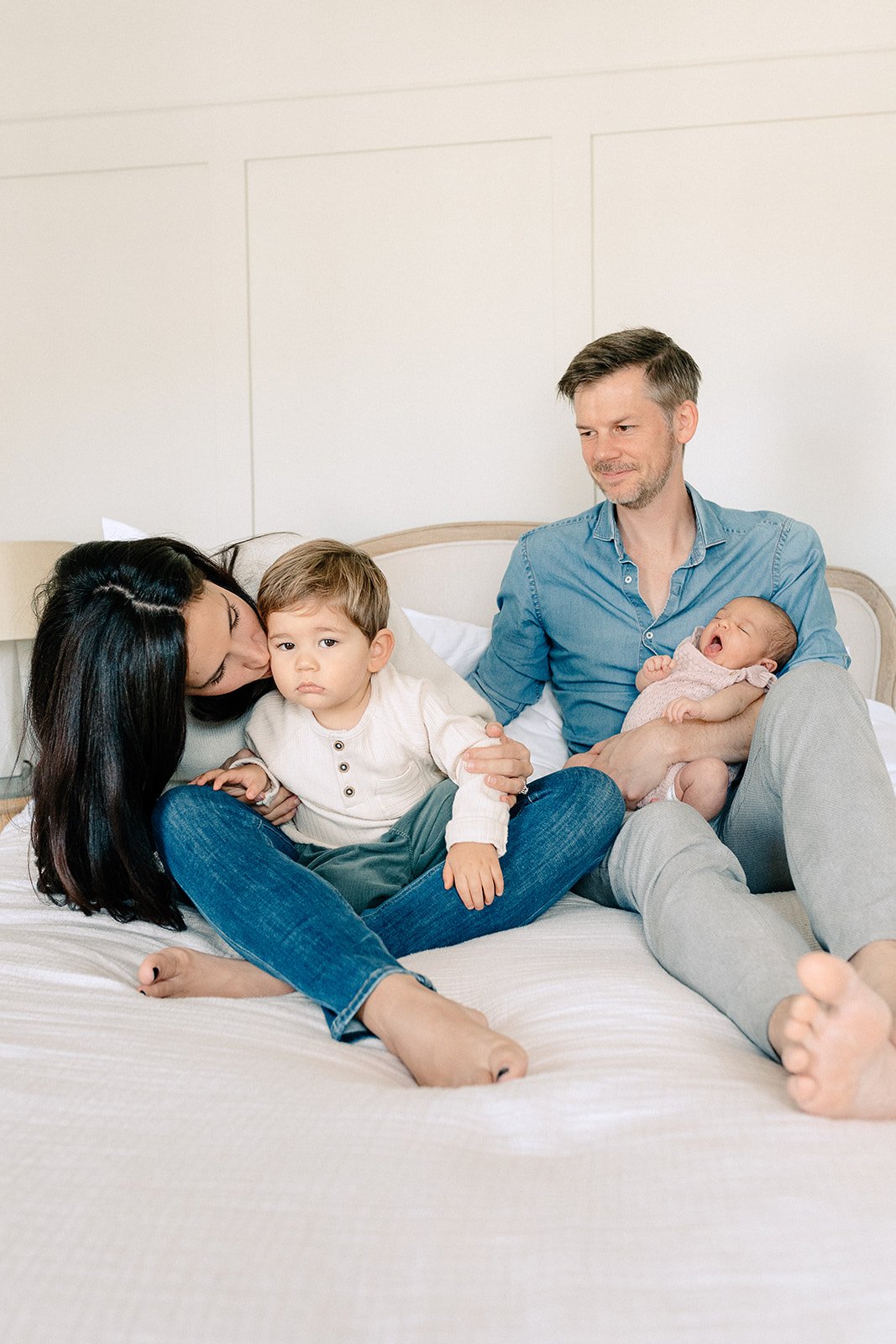  newborn photoshoot family smiling on bed in tunbridge wells 