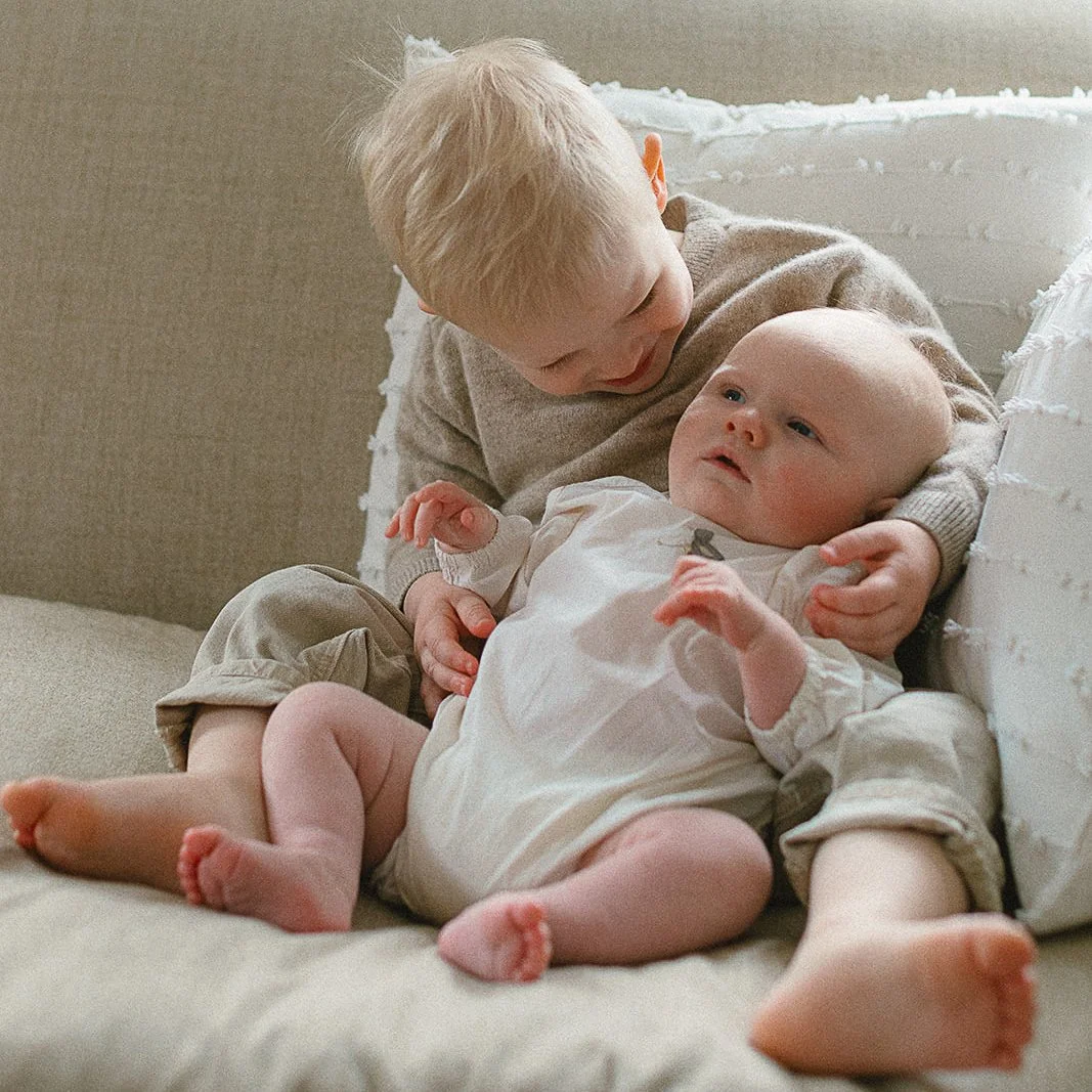 newborn-photographer-tunbridge-wells-sibling-cuddling-newborn.jpg