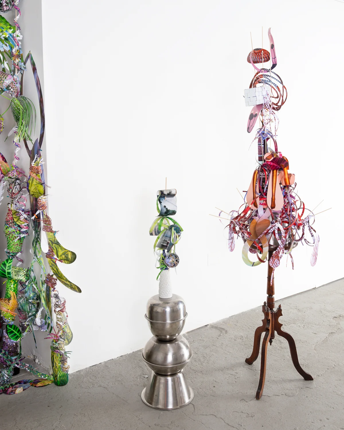 Left to right:   Drift-stitch-channel , 2014  cut-up inkjet prints, c-prints, metal bowls, wooden dowels, and ceramic vases  47 x 15 x 10 inches   Flip-shiver-strain , 2014  cut-up inkjet prints, colander, wooden dowels, book, wire, and wooden table