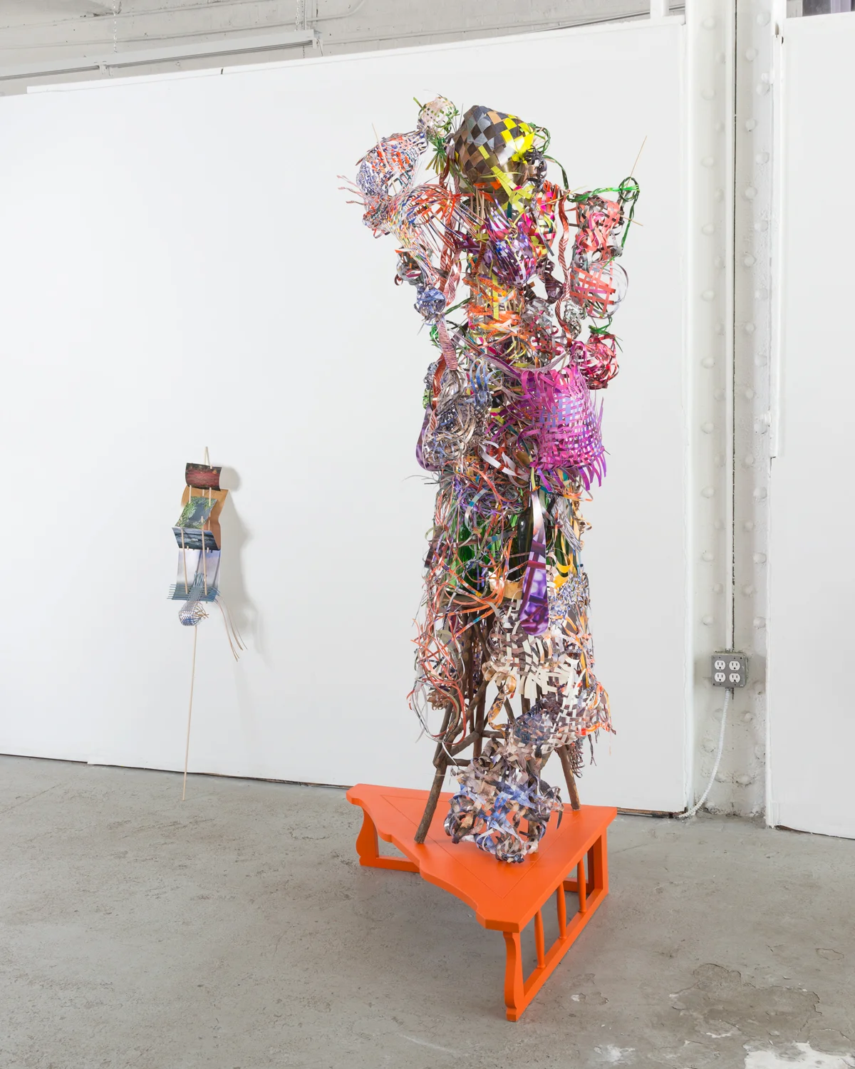     Ravel-swivel-patter-sway , 2015  cut-up pigment prints, wooden dowels, wooden table, miniature clothespins, and glass bottles  75 x 36 x 36 inches  &nbsp;  leaning against wall:   Breezy-outer-edge-falls , 2014  cut-up pigment prints and wooden d