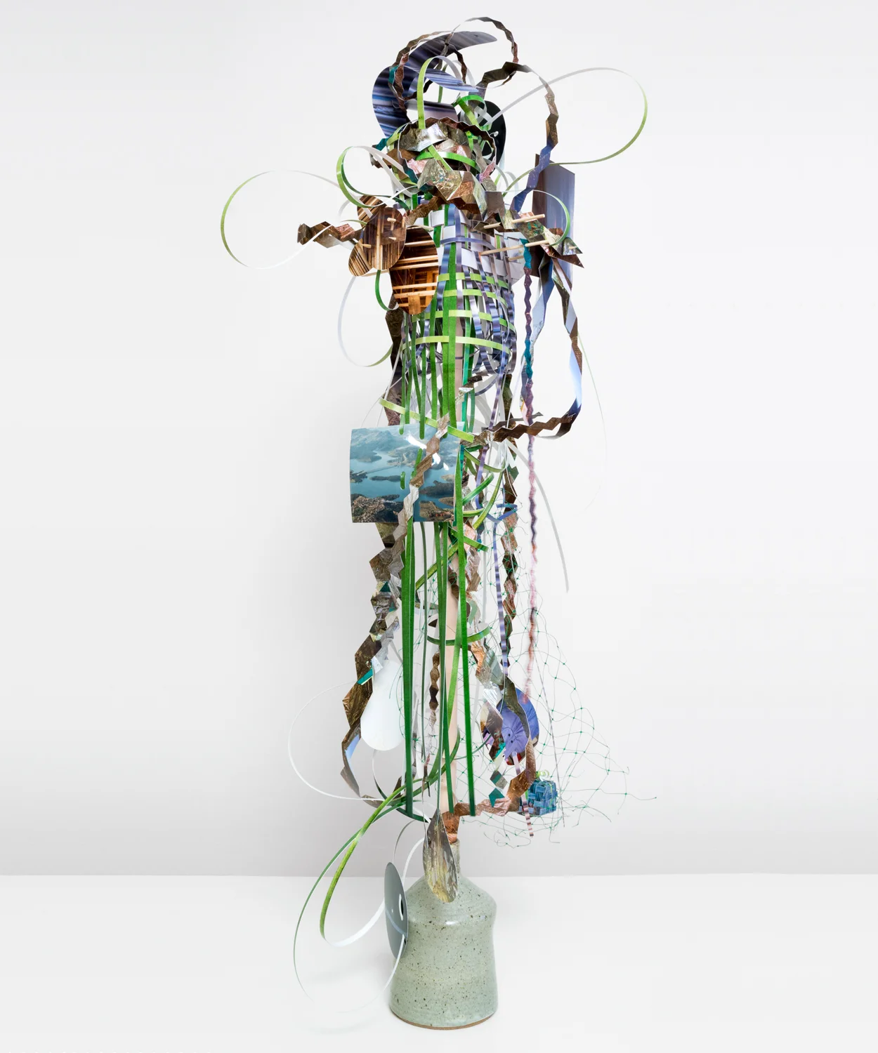   Fret-foil-dangle-glow , 2014  cut-up pigment prints, c-prints, wooden dowels, plastic netting and ceramic jug  42 x 18 x 17 inches   Twist-flip-tremble-trace , Johalla Projects, Chicago, IL 