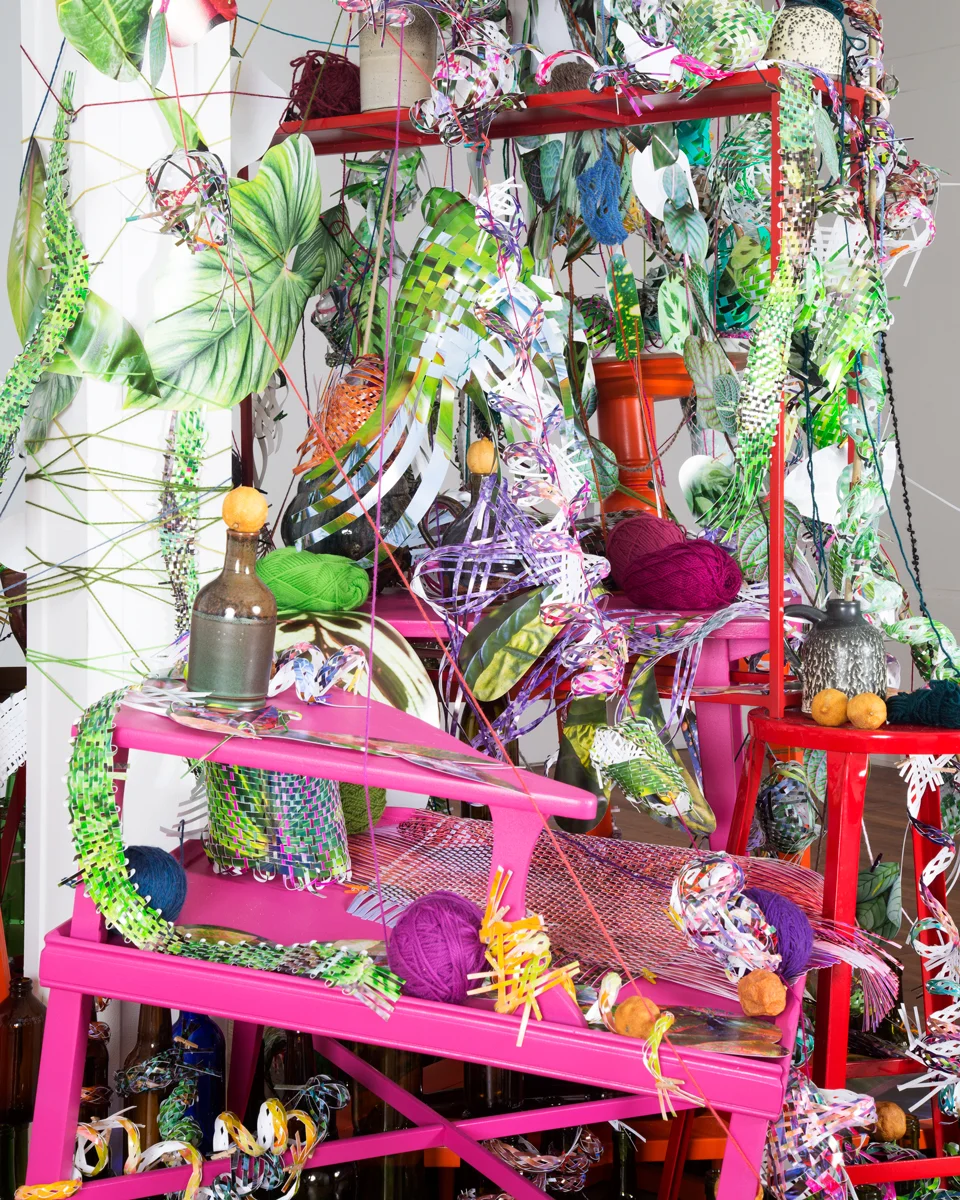   Winter Thicket , 2015  cut-up inkjet prints, yarn, pile of brightly painted furniture, glass bottles, ceramic jugs, dried lemons, dried limes, porcelain vase, shelf   Winter Thicket , Demo Project, Springfield, IL 