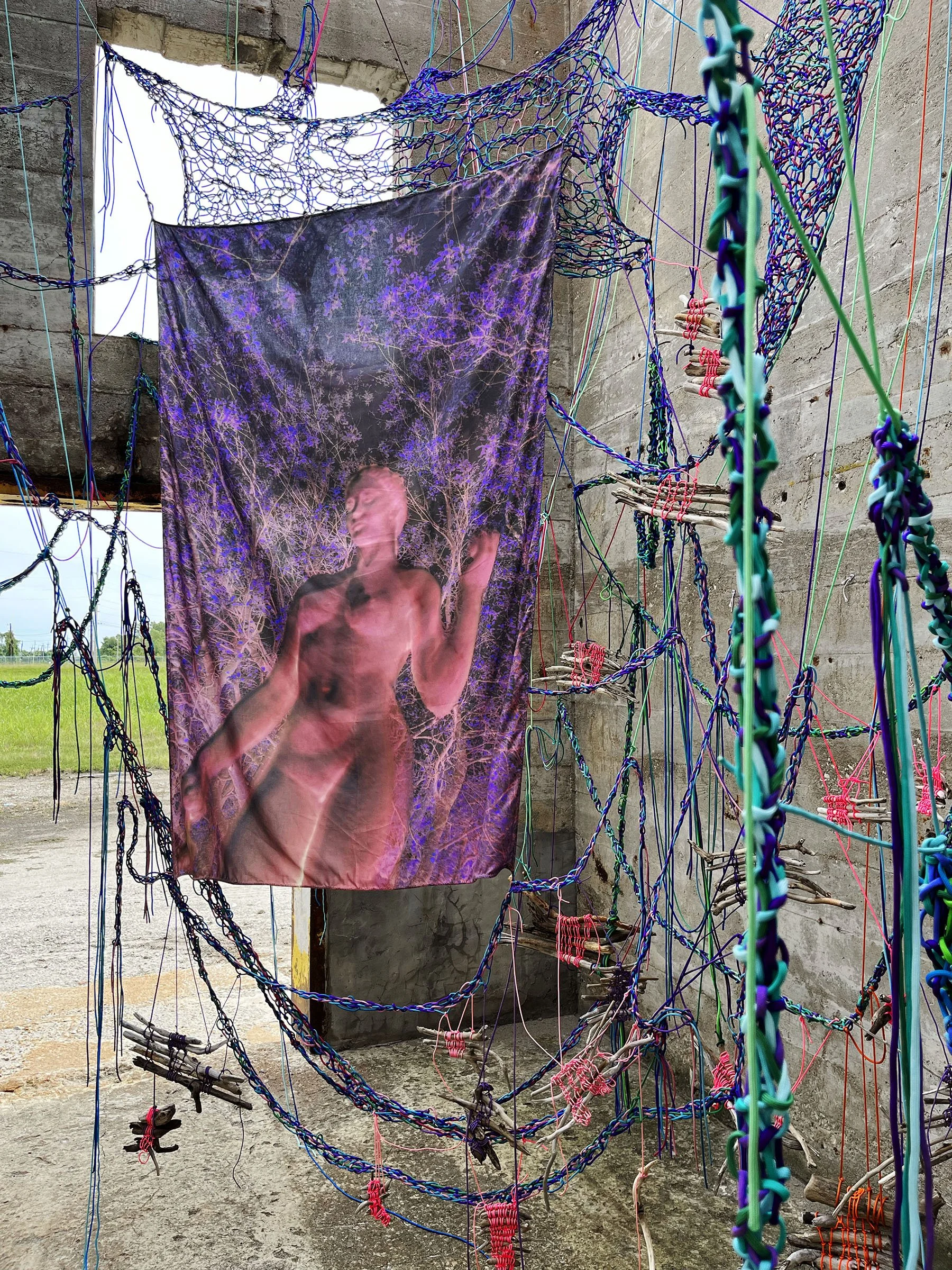 Hold Tight, 2024  Materials: Photographs, paracord, driftwood  Dimensions: Site-specific installation in 418 square foot unconventional, outdoor exhibition space with 15foot tall walls  Exhibition: Solo exhibition at NON STNDRD, Sauget, IL 