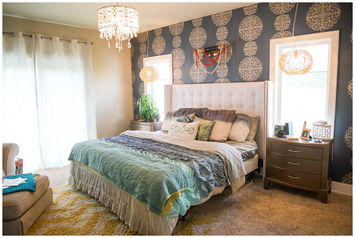 On to her bedroom. Salina and Roy made the tufted headboard themselves. The short shag rug is from Fresh Digs as is the vintage bull horn rack above the bed. Two natural round lights hang above the bedside tables and another fantastic light hangs above. And how about that wallpaper?