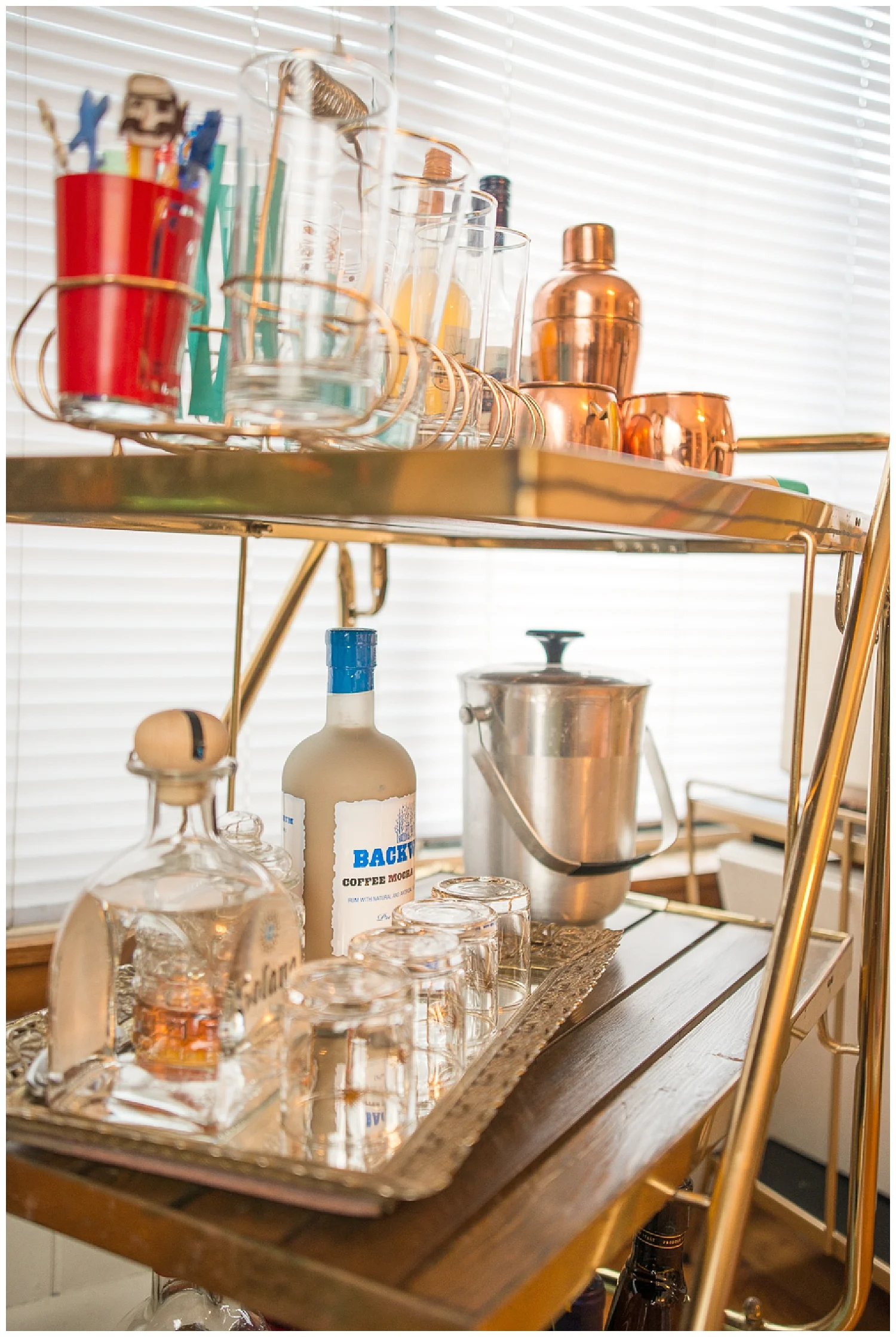 Her fave thing is this vintage bar cart that she got from Fresh Digs. Most of what’s on it are thrift store finds. I love the gold glass carrier and the gold vanity tray she's using to hold barware. 