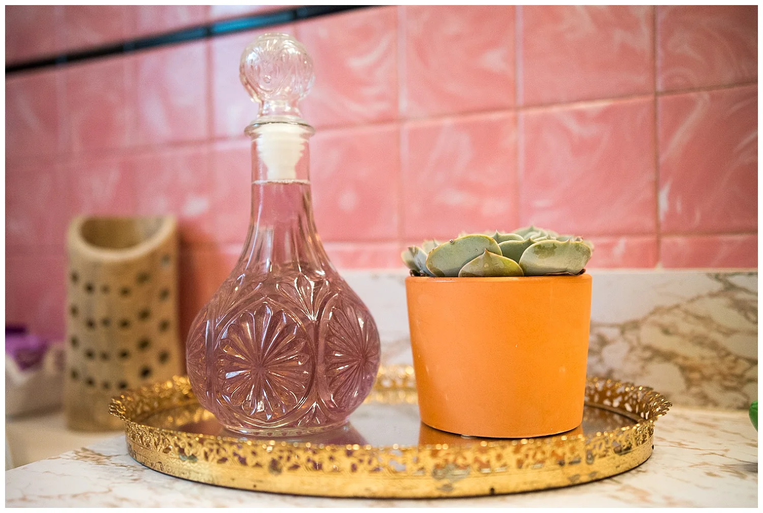 Bathroom in marble and pink. The family share one bathroom and guess what’s in the vintage decanter? Mouthwash. : ) And here again she's using a vintage vanity mirror. 