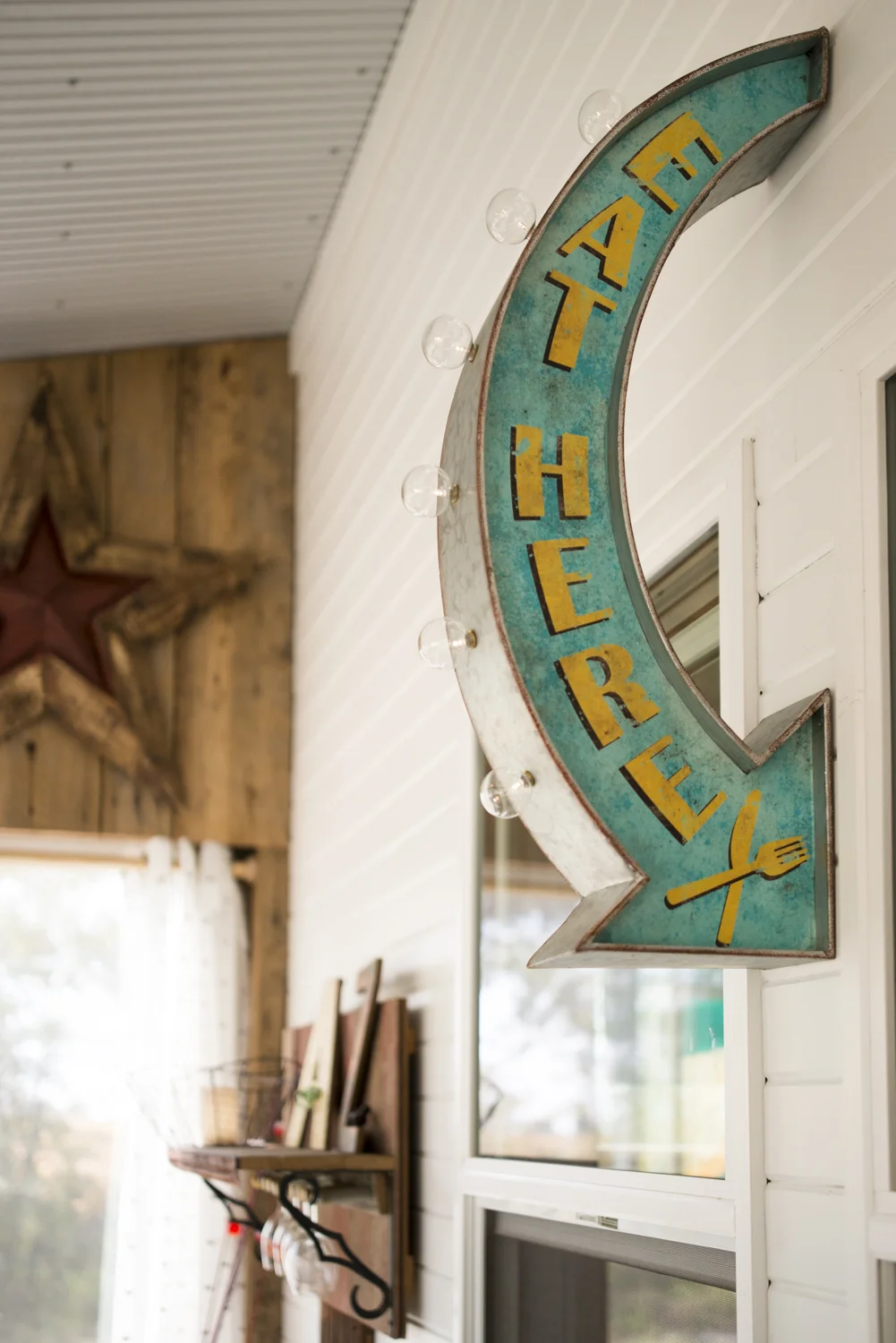 The fun "Eat Here" sign points to the window that looks out from the kitchen/dining area into the sunroom.