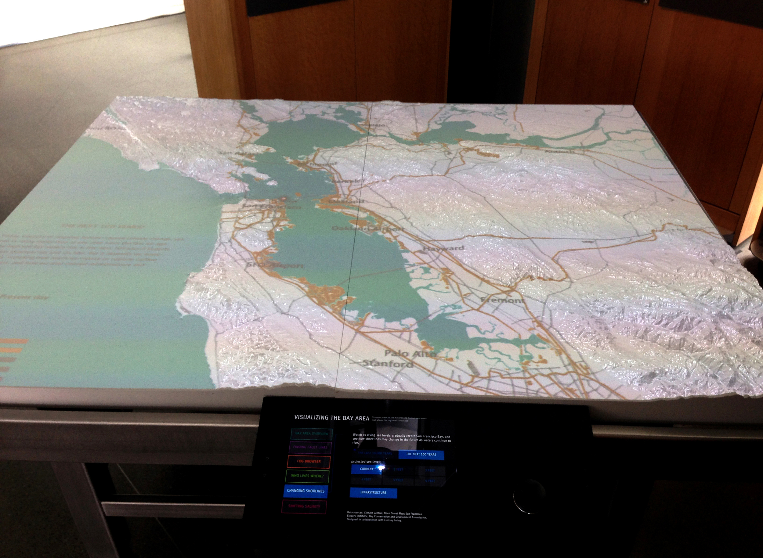 Visitors can select the "Past 18,000 years" or "the Next 100 years" on a tablet and scroll through sea level elevations that are projected onto the 3D table. Data sources: USGS, NOAA, SFEI, Climate Central, UC Santa Barbara, MapZen's OSM MetroExtrac