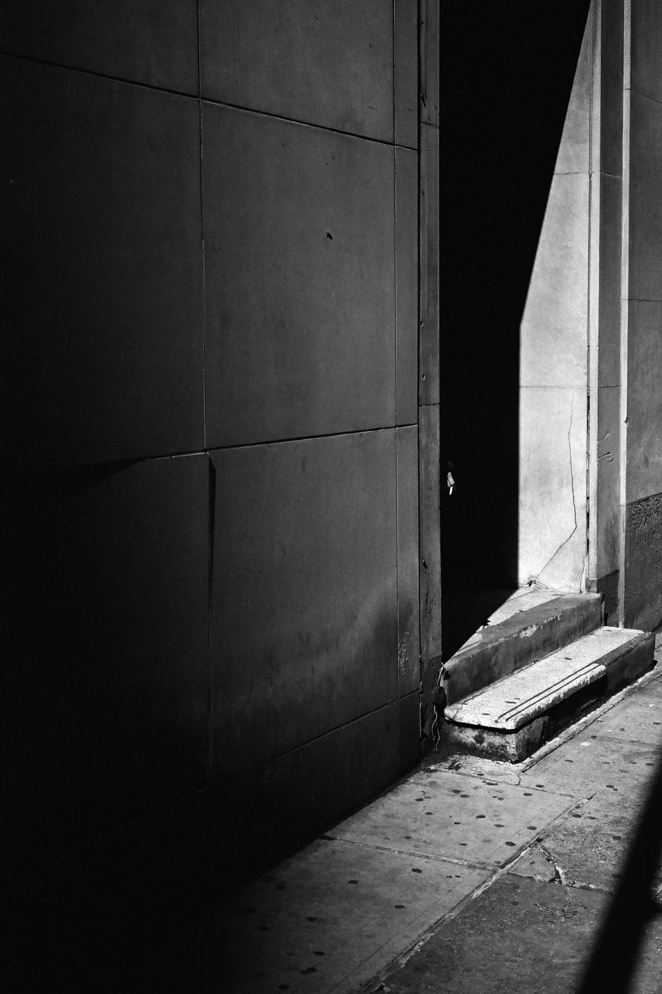 A man flicks cigarette ash while sheltering from the wind on New Street.