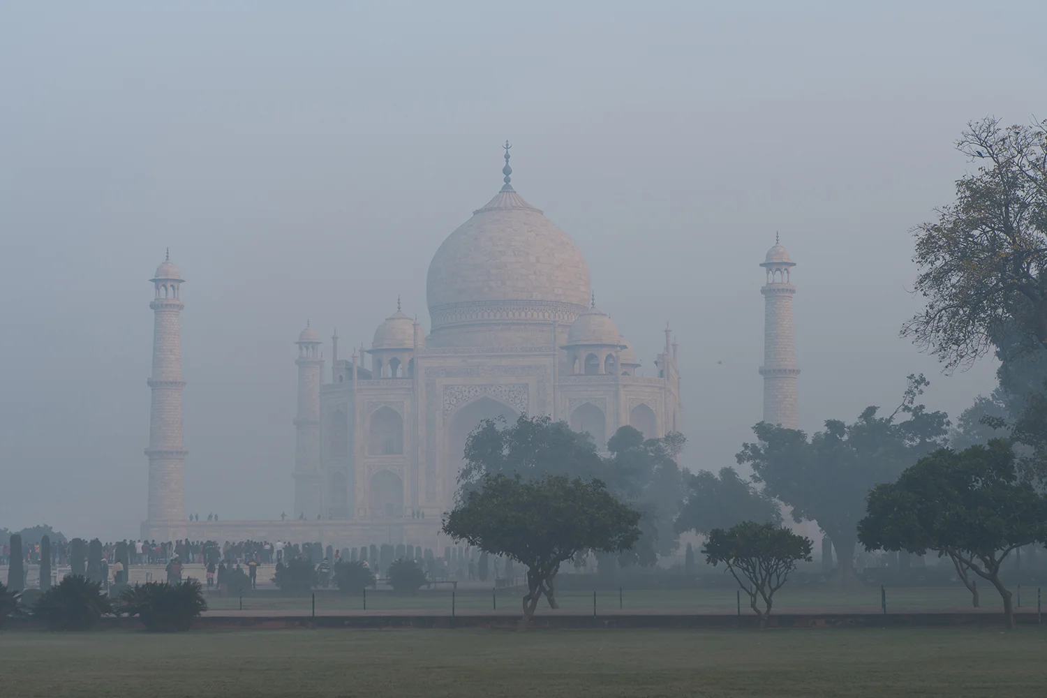 Orange glow from the rising sun on the white marble of the Taj Mahal.
