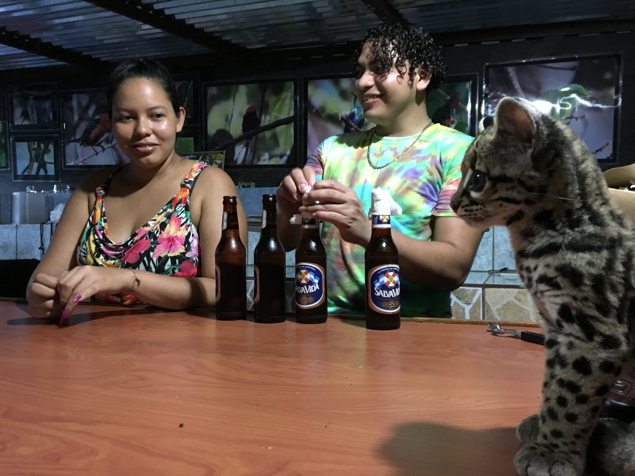 Ocelot and beers. The women who helped tend the young ocelot until its big enough to roam the forest on its own.