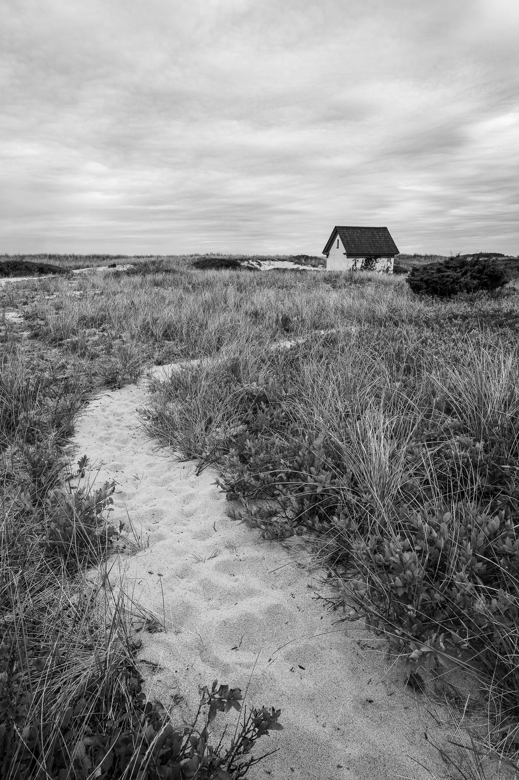What Waits Ahead:
The horizon holds no promises, only questions. The small structure at its edge becomes a symbol less of shelter than of anticipation, reminding us that what lies ahead is always partly hidden, partly imagined. This image is not ab