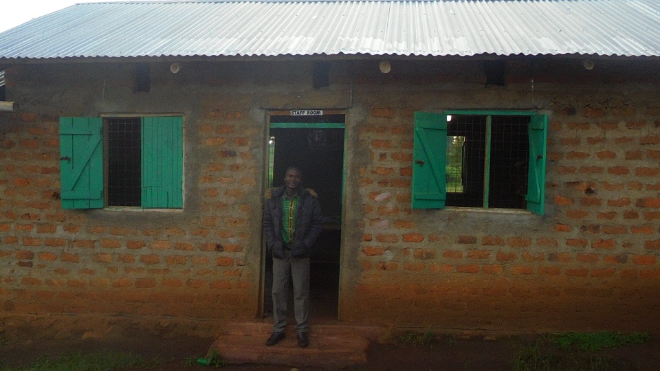 Moses, our science teacher, standing in front of the staffroom, where the administrative staff work and the teachers keep their supplies