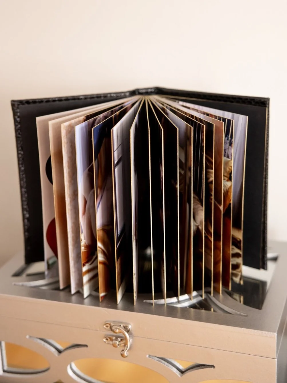A gilded gold photo album, or little black book, with your photographs, placed in a silver triple goddess boudie box.