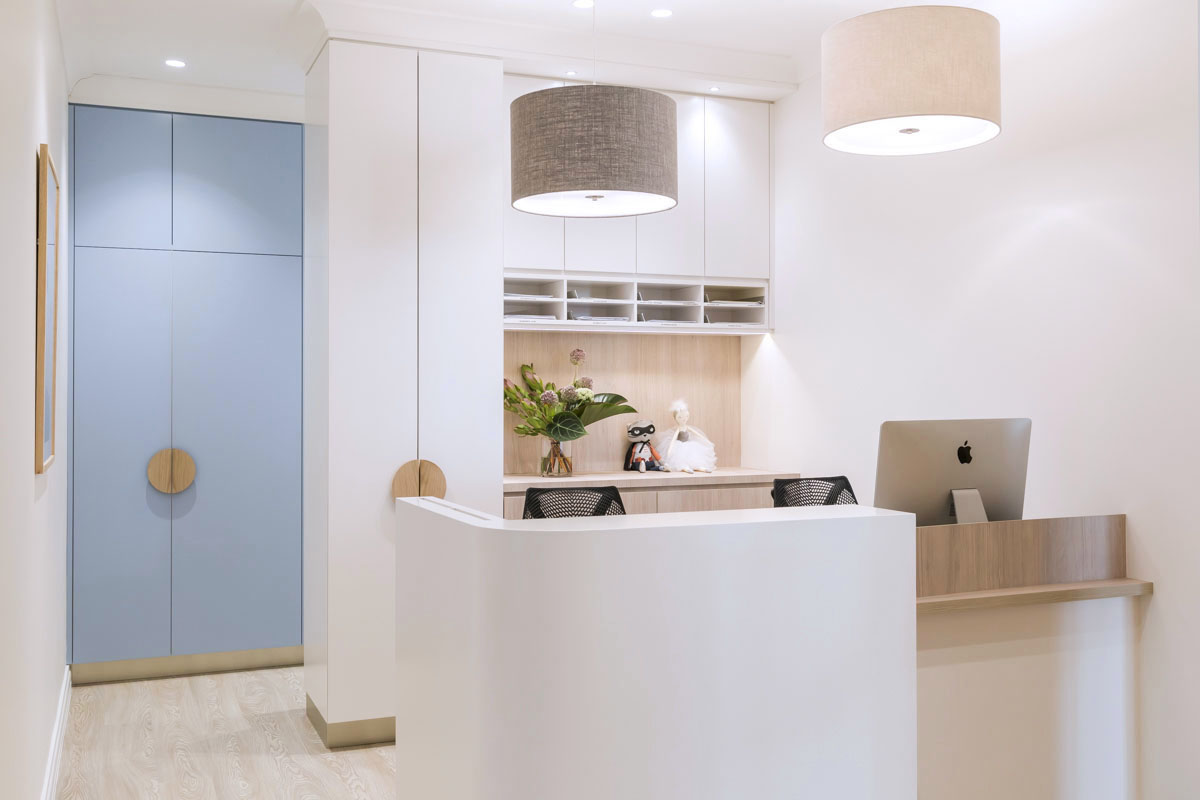 The reception desk was relocated to face the entry, providing a practical and friendly welcoming space for patients.