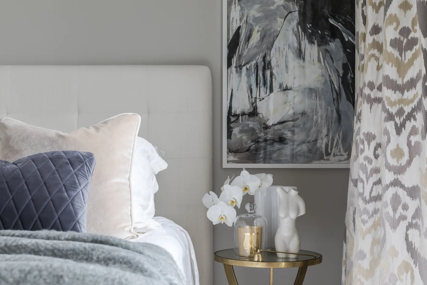 At Jersey Road, the metallic side table and accessories add a warm glow to the master bedroom.