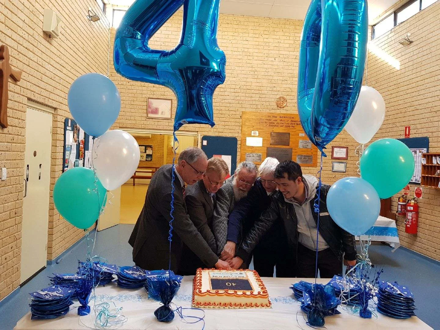 Minister's, past and present, cutting the Anniversary Cake