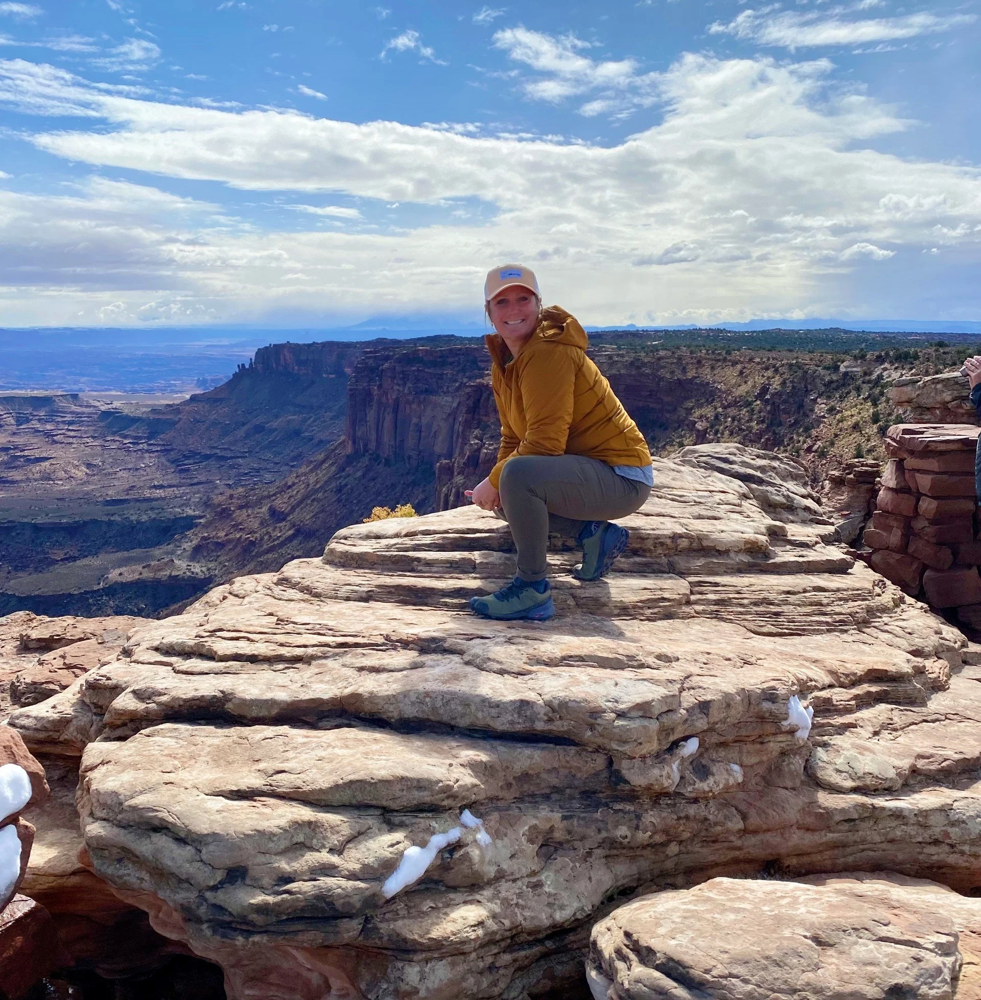Becky sitting on top of a mountain.