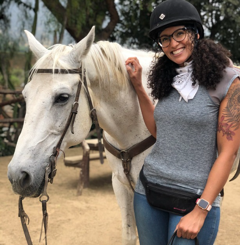 Nicole Snell posing next to a horse.