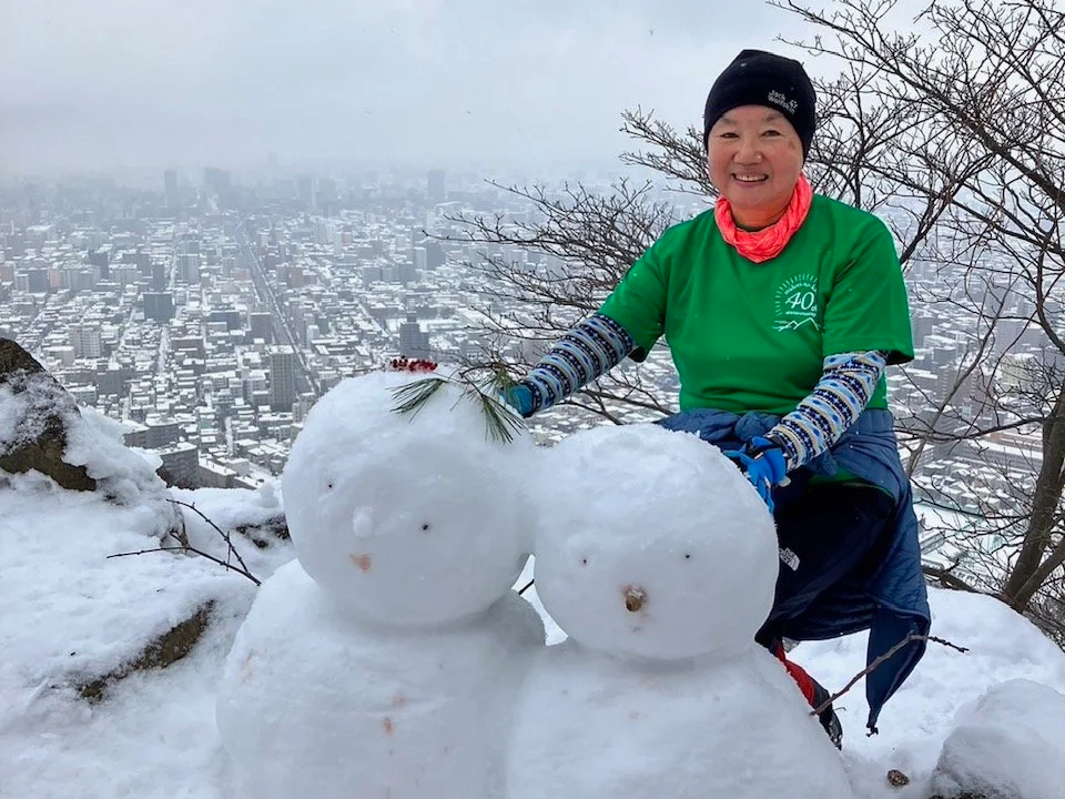 Smiling Japanese woman with 2 snowmen