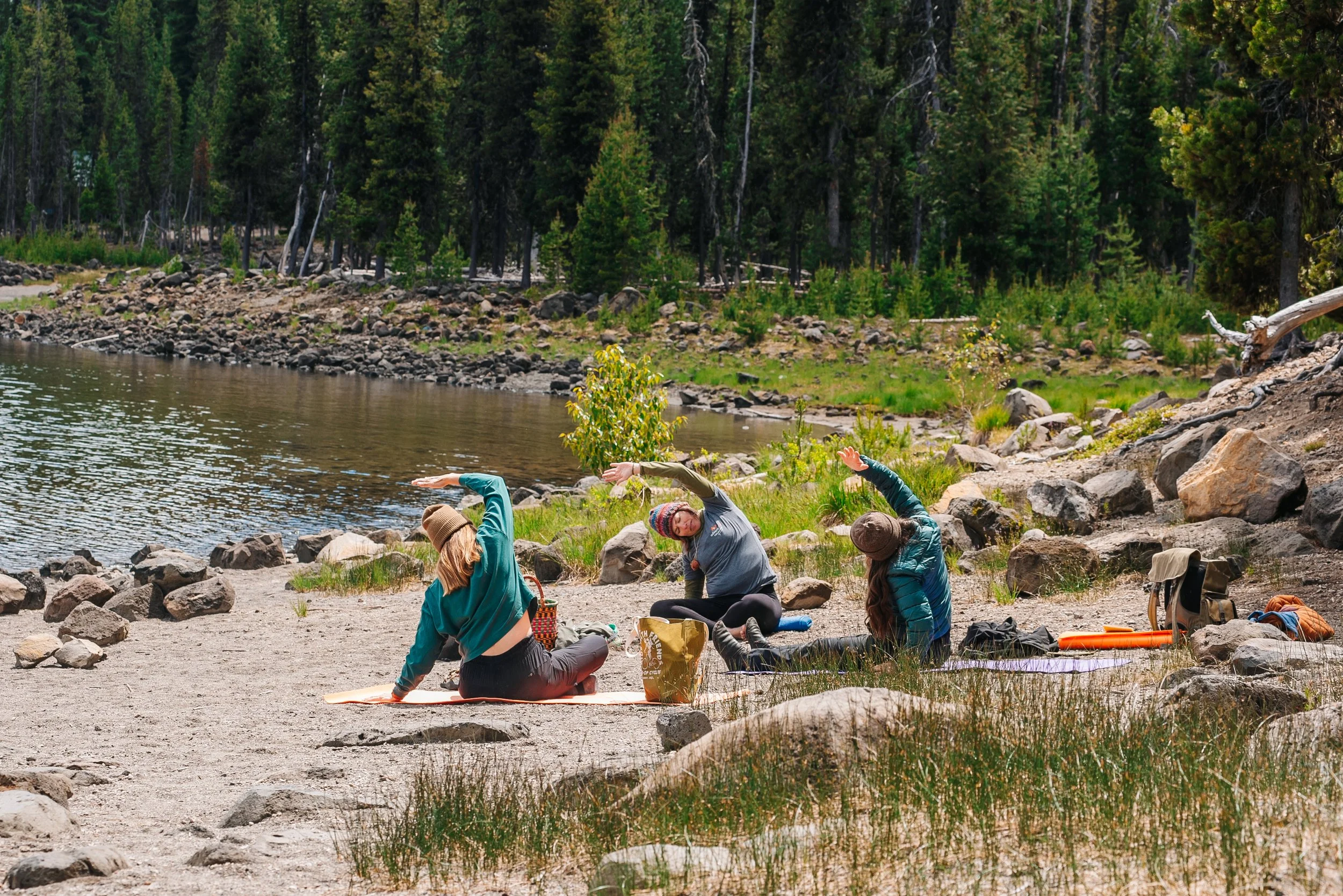 Women doing yoga next to a lake