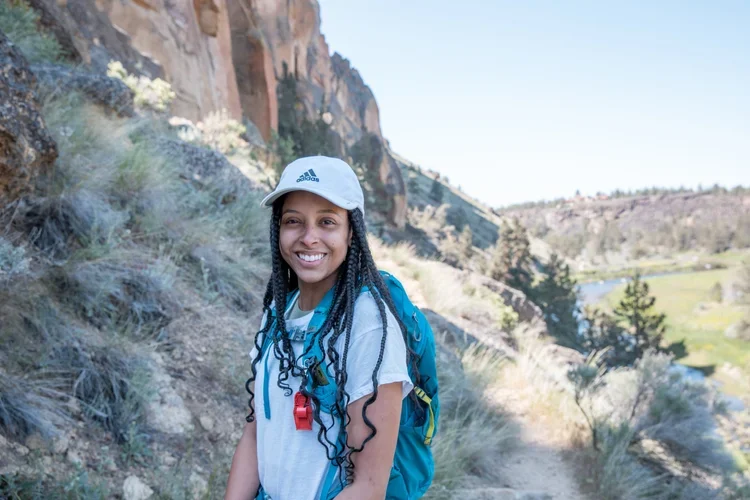 Woman hiking at Smith Rock State Park as part of a guided outdoor adventure trip organized by AdventurUs.