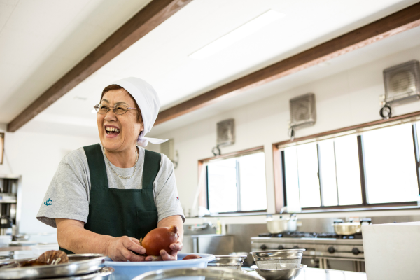 Japanese woman smiling teaching cooking class