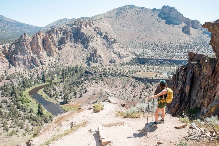 Hiker overlooks a canyon river from a cliffside trail on an AdventurUs adventure.