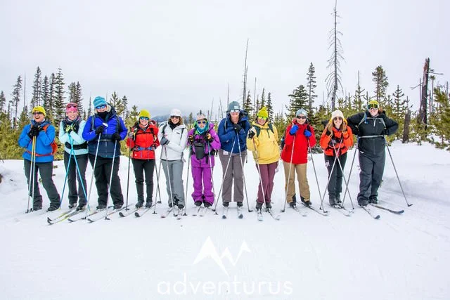 A group of women posing for a picture at a winter retreat organized by AdventurUs.