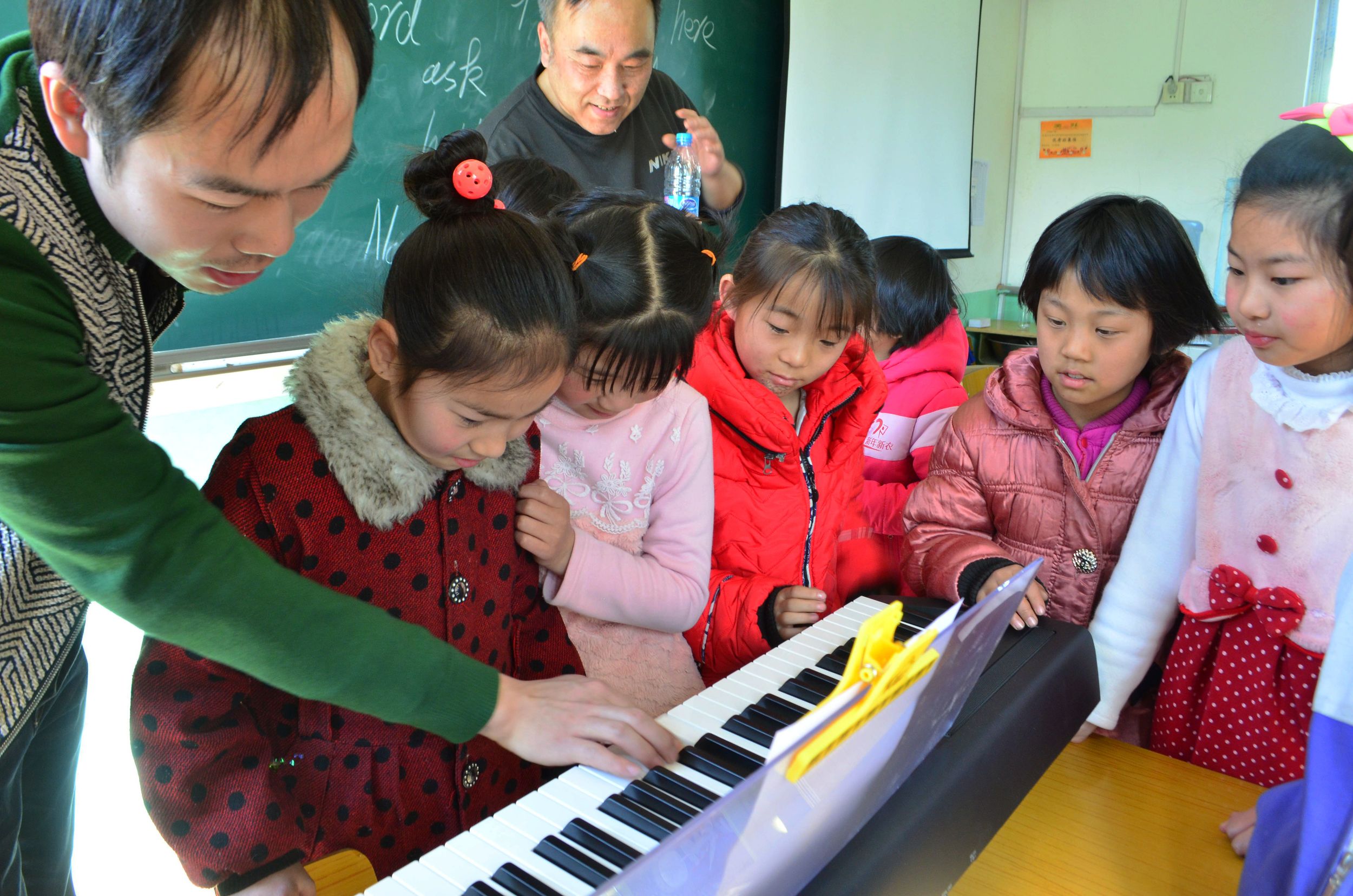_Teacher and students playing piano老师在教学生弹琴.jpg
