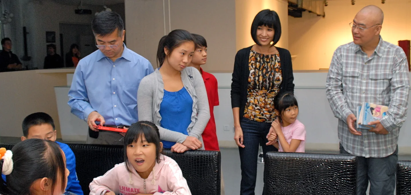 Ambassador Locke and his family and author Zheng Yuanjie (right) take part in an art activity with migrant children (sitting) in Beijing, September 2011. (Courtesy of US Embassy, Beijing) 