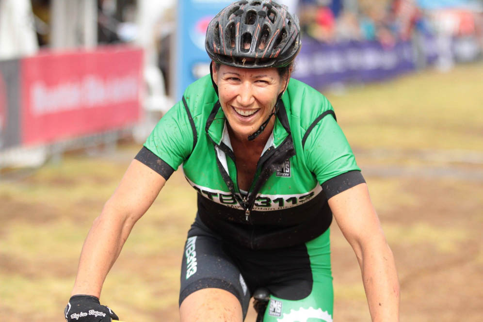 Wendy on the MTB, muddy and smiling.