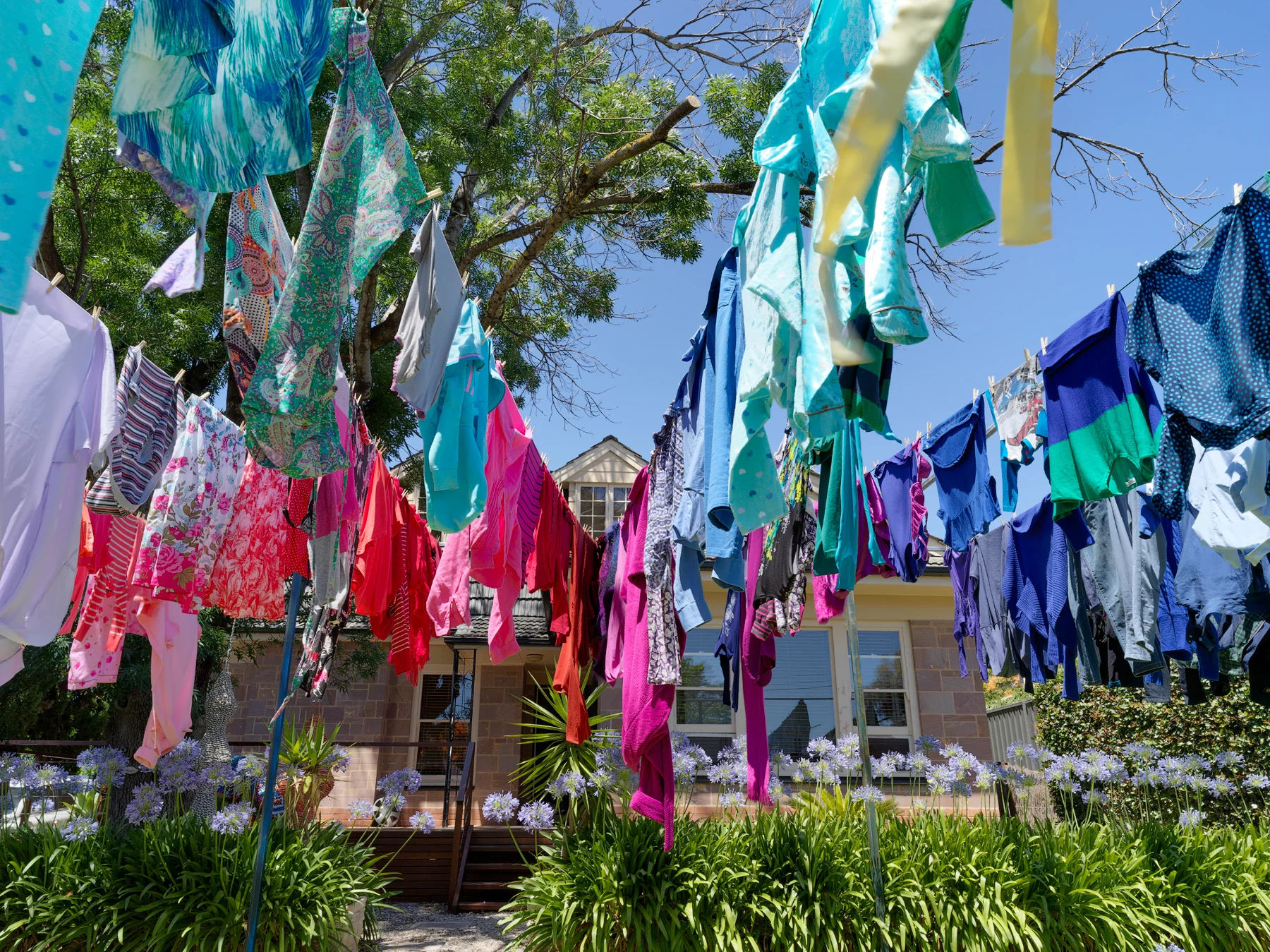 Airing our dirty laundry 2017 300 x 700 x 1100cm discarded clothes donated by my neighbours, steel, plastic coated wire, wooden pegs Photographer Grant Hancock